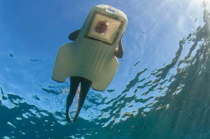 A clear-bottom sea board seen from below the surface
