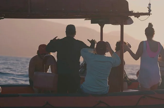 Silhouettes of guests on a raft at dawn