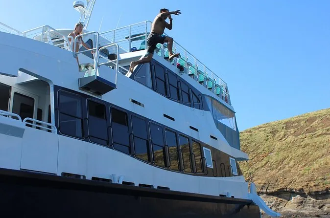 A guest jumping from the upper deck of the Calypso into blue water